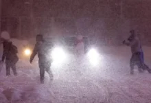 A weather satellite map showing a large blue-and-white storm front approaching the California coast.