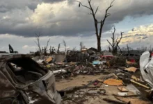 Heavy debris blocks rural roads following the destructive Michigan tornado outbreak.