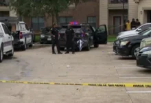 An HPD patrol car with blue and red lights flashing at a cordoned-off intersection in Southwest Houston.