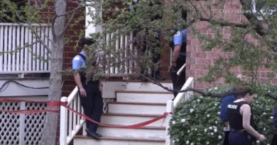 Police vehicles and yellow crime scene tape at a residence in the Homan Square neighborhood of Chicago.