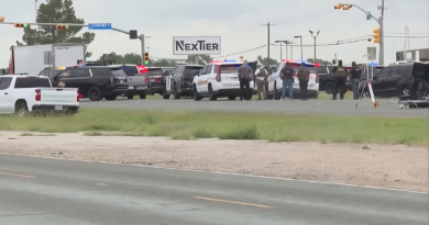 A police vehicle on a highway in Midland, Texas, with emergency lights flashing.